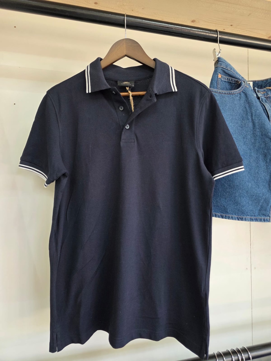Tee Jays navy polo shirt with white stripe accents — front view