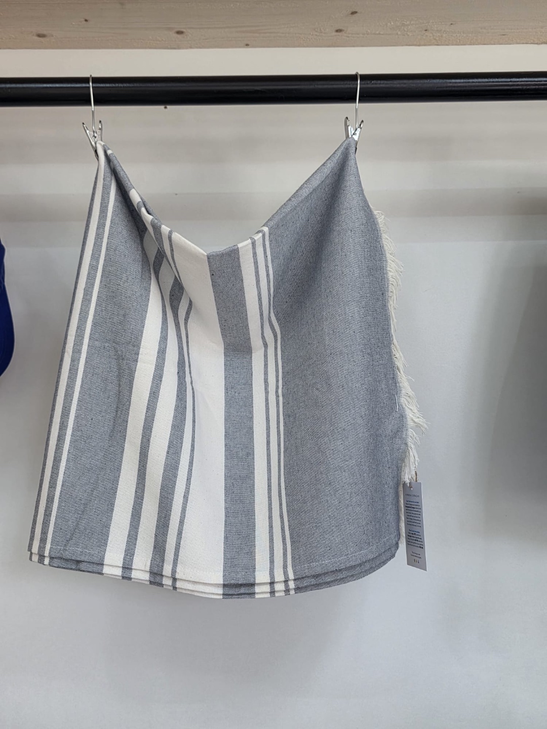 Blue Loop Originals strandlaken van gerecyclede jeans — hangend in de winkel
